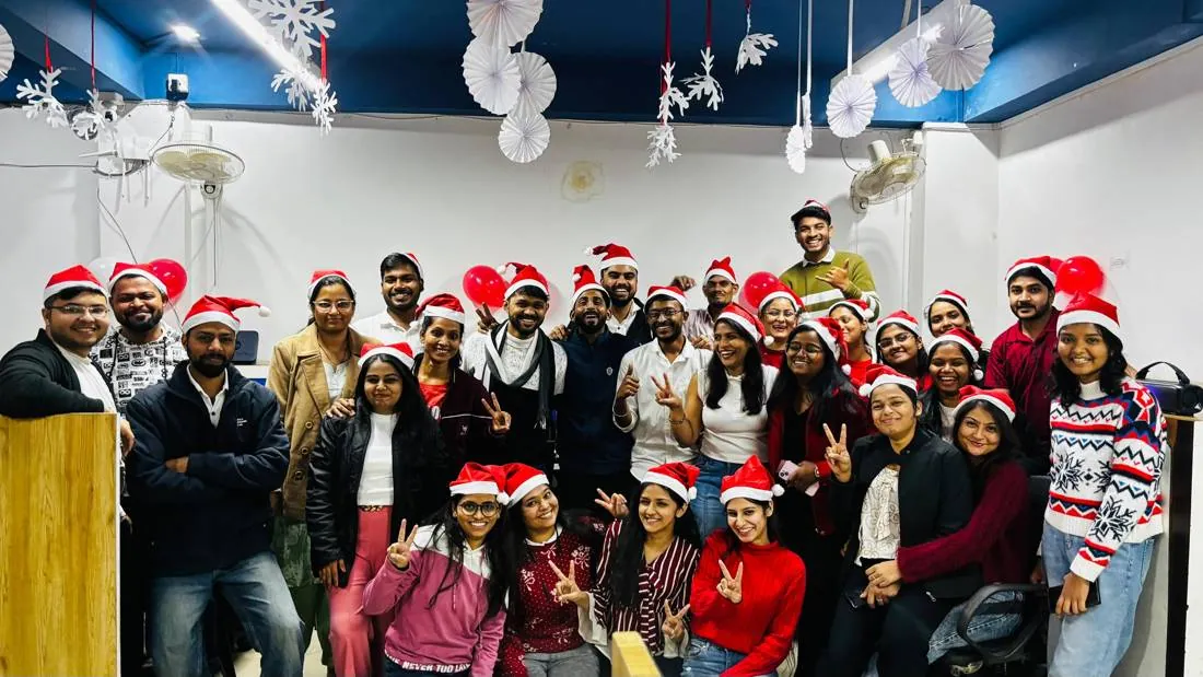 The whole team in Santa hats at the office Christmas party