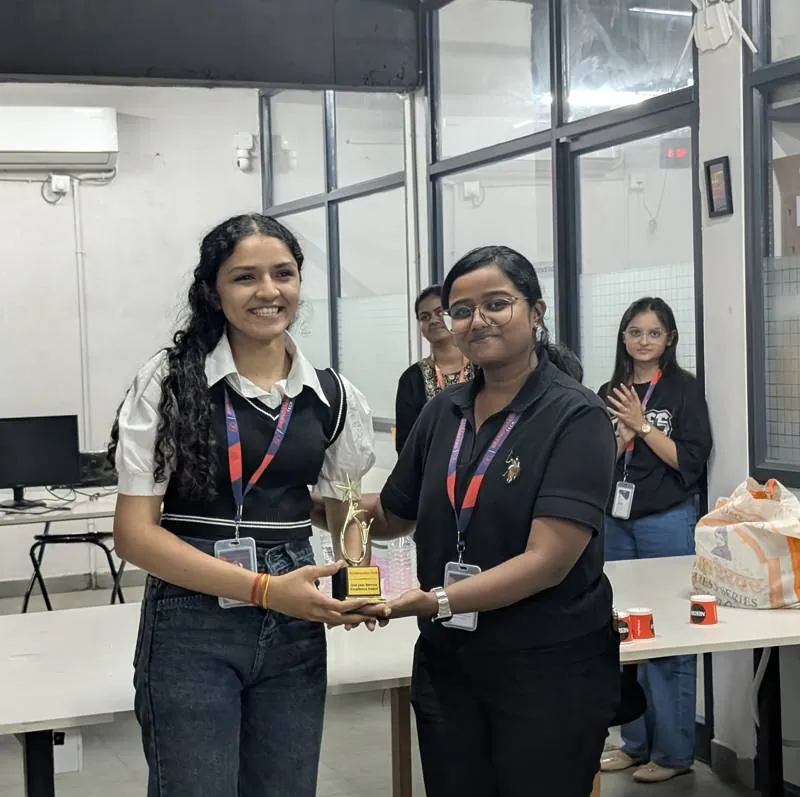 Two colleagues holding an award at a milestone celebration